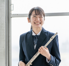 フルートを持って笑顔を見せる学生