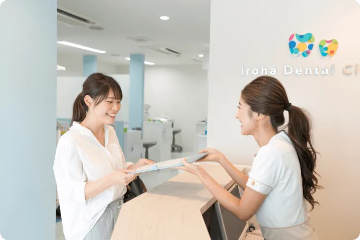 京都市右京区西院の矯正歯科 いろは歯科西院の受付スタッフが無料相談に来たお客様の応対している