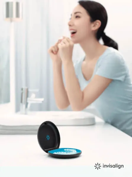 洗面台でインビザラインを装着している女性の姿